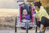 Mutter joggt mit Baby im Kinderwagen