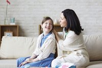 Mutter im Gespräch mit Tochter auf dem Sofa