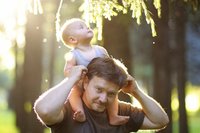Vater trägt Baby auf den Schultern