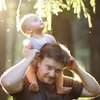 Vater trägt Baby auf den Schultern