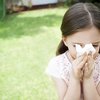 Kita-Kind mit Allergie putzt sich im Garten die Nase