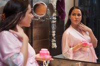 Schwangere Frau im Badezimmer vor dem Spiegel