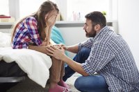 Kommunikation in der Pubertät: Vater spricht mit weinender Tochter