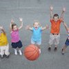 Kinder werfen einen Basket Ball nach oben