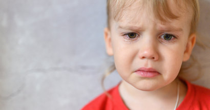 Portrait von kleinem Kind, das weint. rotes Shirt.