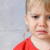 Portrait von kleinem Kind, das weint. rotes Shirt.