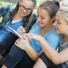 Drei Jugendliche beim Schüleraustausch machen gemeinsam Notizen