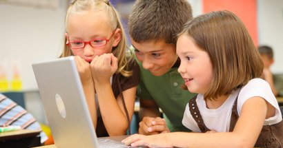 Drei Grundschulkinder am Laptop