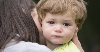 Mutter mit weinendem Kind auf dem Arm