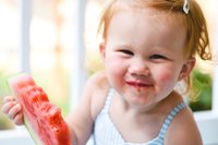 Kleinkind Mädchen isst eine Wassermelone.
