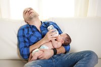 Vater erschöpft, füttert Baby