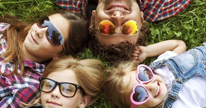 Familie liegen mit Sonnenbrillen im Gras