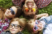 Familie liegen mit Sonnenbrillen im Gras
