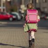 Grundschulkind mit Rucksack geht alleine zur Schule