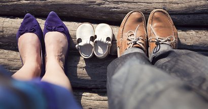 Füße der Eltern neben den Schuhen des Kindes
