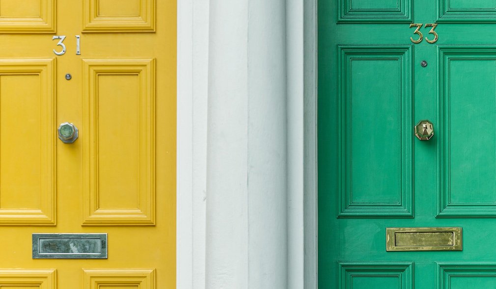 Zwei Türen im Ausschnitt. Gelbe und grüne Tür