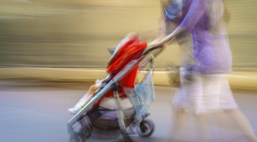 Mutter schiebt Baby im Kinderwagen
