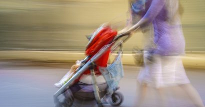 Mutter schiebt Baby im Kinderwagen