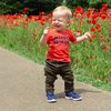 Kleinkind Junge freut sich über Blumen. T-Shirt Happy Human.