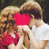 Verliebte Kinder halten Herz vor ihre Gesichter