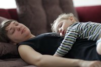Mutter schläft mit Kind auf dem Bauch