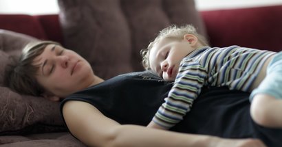 Mutter schläft mit Kind auf dem Bauch