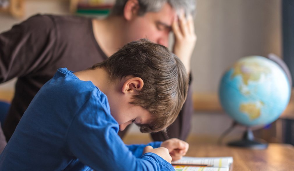Vater hilft Sohn bei den Hausaufgaben. Mit Frustration
