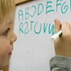 Kind schreibt das Alphabet an Tafel