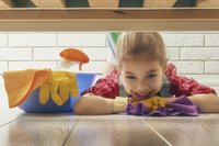 Hilfe im Haushalt: Kind putzt und blickt unter das Bett