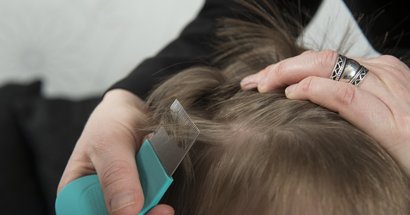 Mutter untersucht die Haare ihres Kindes auf Kopfläuse