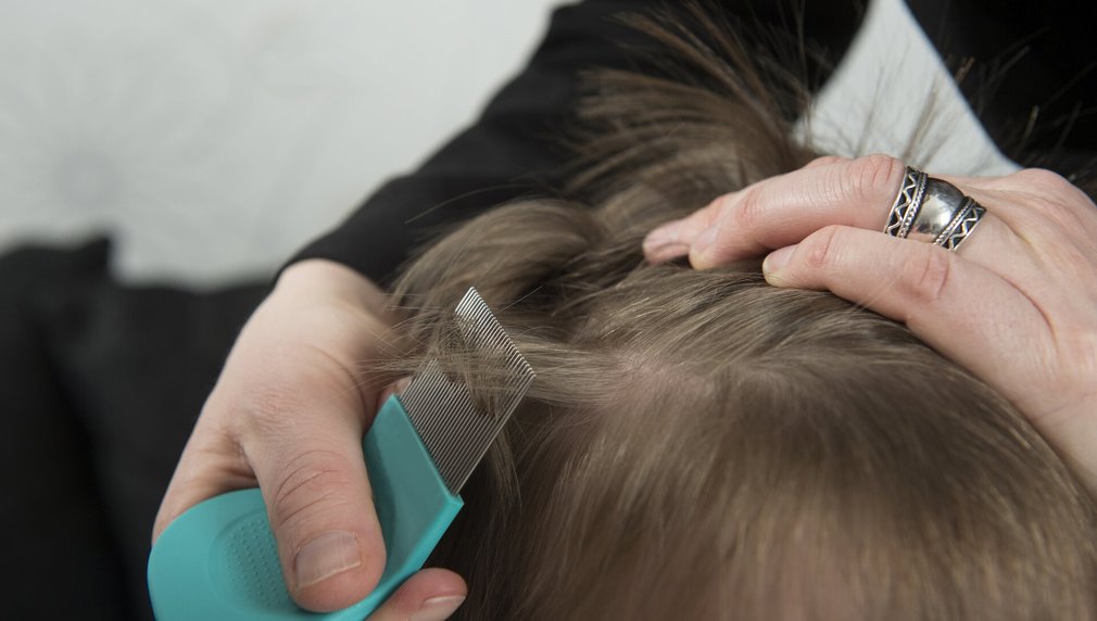 Mutter untersucht die Haare ihres Kindes auf Kopfläuse