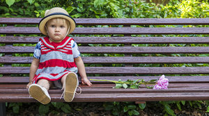 Kleinkind schmollen sauer mit Hut sitzt auf Bank
