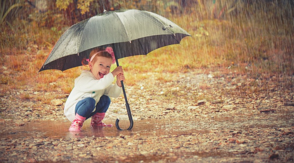 Kind an der frischen Luft - bei Regen unterm Regenschirm