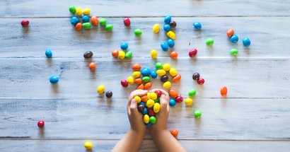 Kinderhände, die Süßigkeiten festhalten
