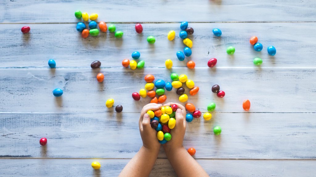 Kinderhände, die Süßigkeiten festhalten